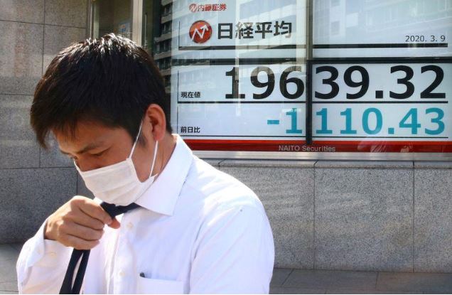 شاشة إلكترونية تعرض متوسط المؤشر نيكي للأسهم اليابانية خارج مكتب للسمسرة في العاصمة طوكيو يوم 9 مارس 2020. تصوير: إدجار جاريدو - رويترز.